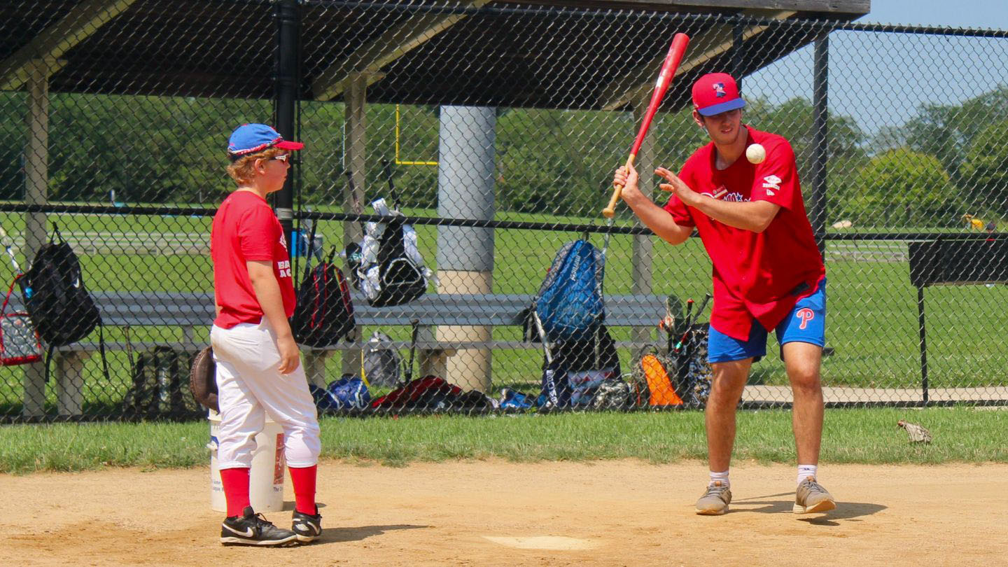 Coach hitting grounders